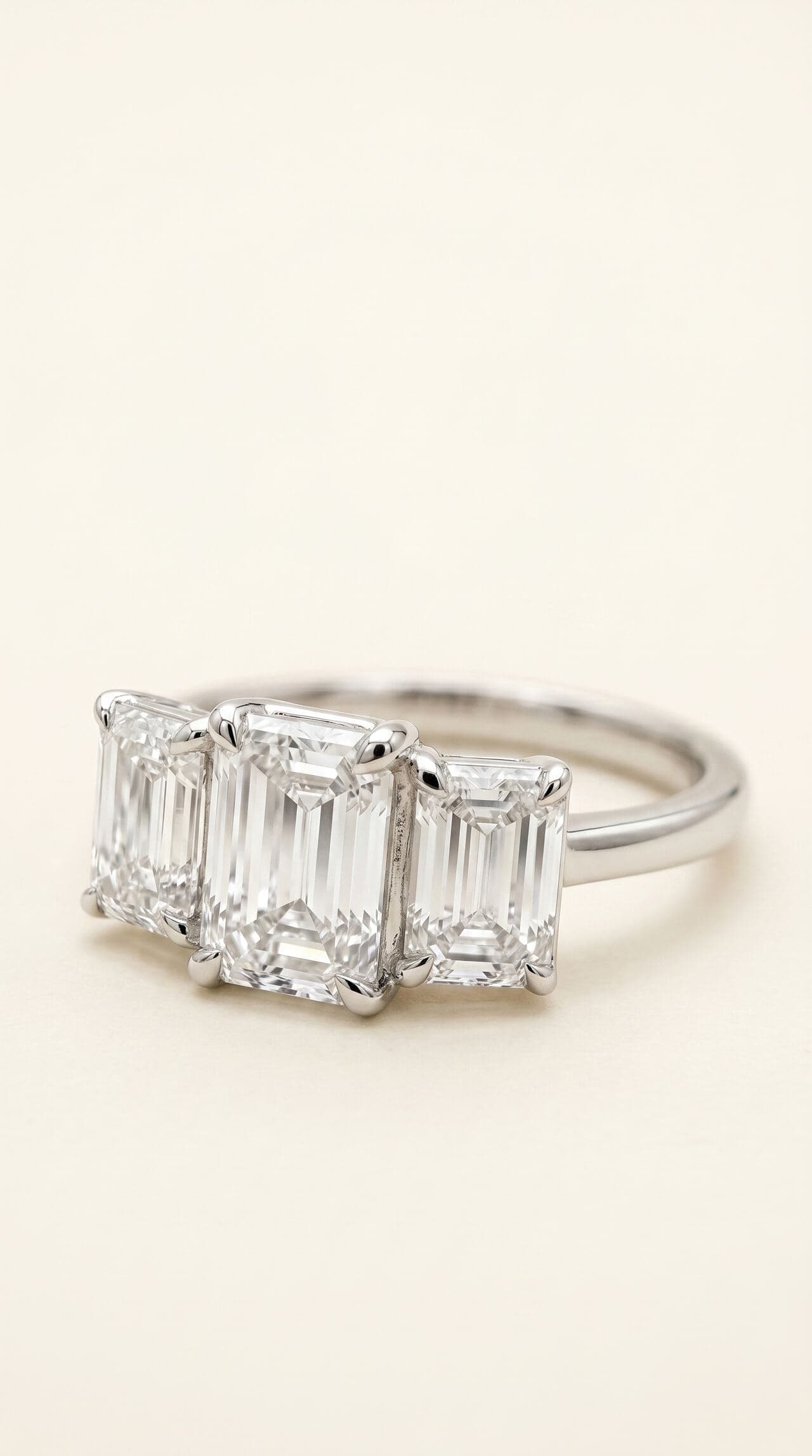 Emerald cut trilogy diamond ring in white gold, studio editorial photograph