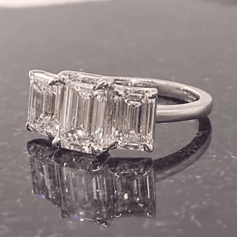 Three-stone emerald cut diamond ring in white gold, front view