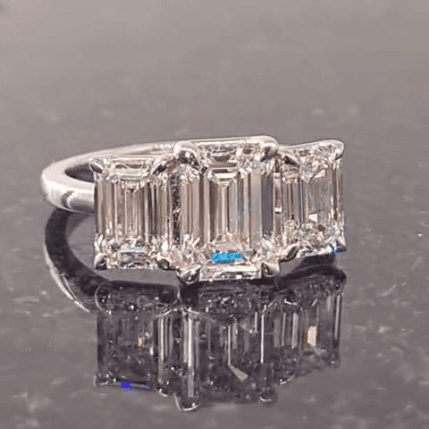 Side profile of an emerald cut trilogy diamond ring in white gold